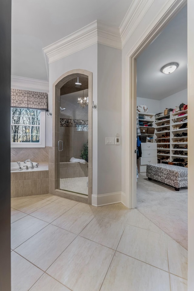 bathroom featuring a spacious closet, ornamental molding, a stall shower, and tile patterned floors