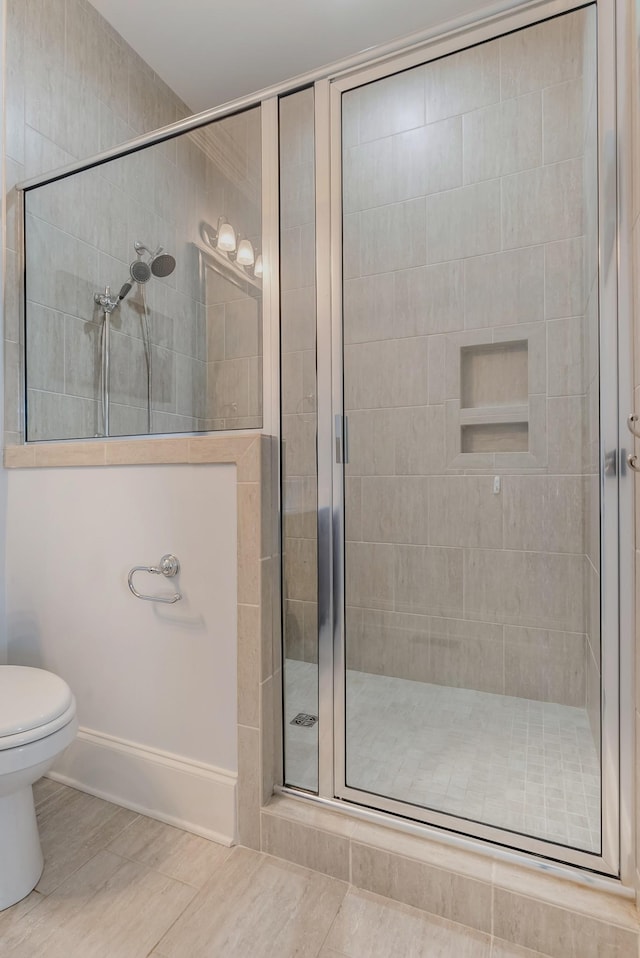 bathroom with a shower stall and toilet