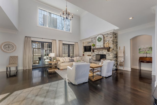 living area with plenty of natural light, dark wood finished floors, crown molding, and french doors