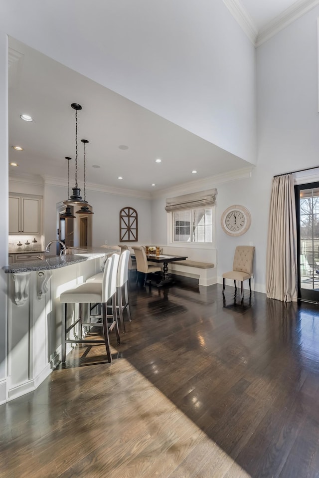 dining room featuring dark wood-style floors, baseboards, crown molding, and recessed lighting