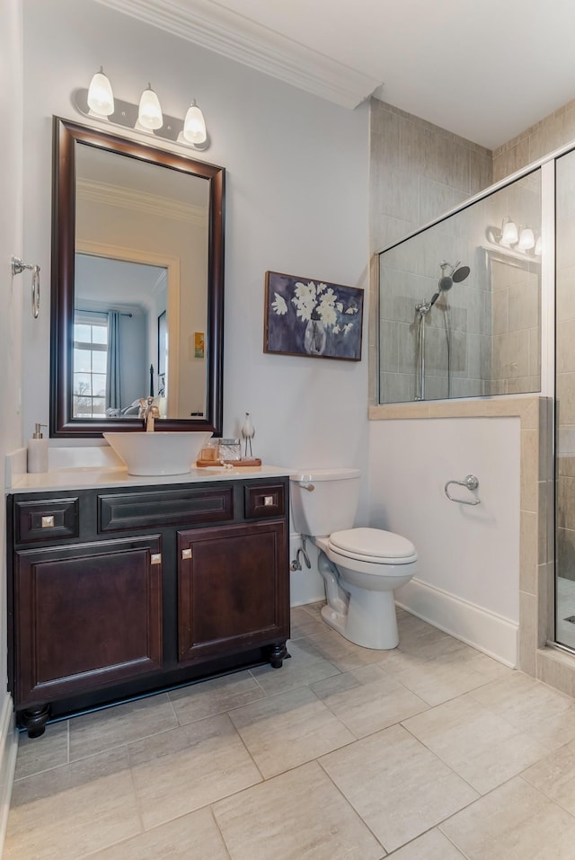 bathroom with toilet, a shower stall, crown molding, and vanity