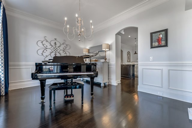 living area featuring dark wood-style floors, wainscoting, arched walkways, and ornamental molding