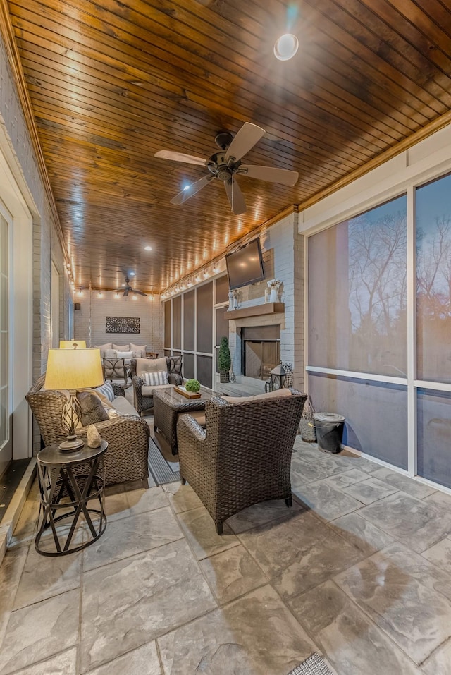 interior space with ceiling fan and an outdoor living space with a fireplace