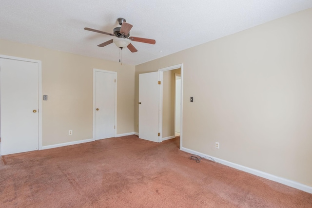 carpeted spare room with baseboards and a ceiling fan