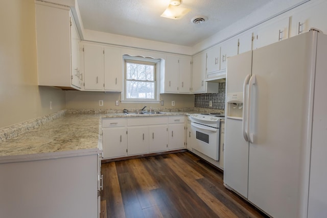 kitchen with white appliances, visible vents, dark wood finished floors, light countertops, and a sink