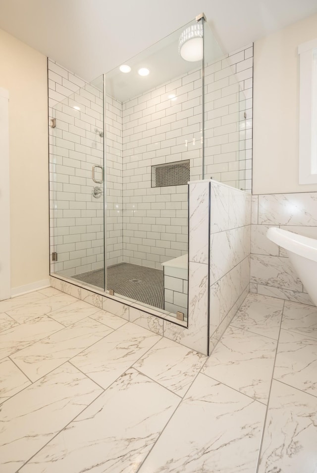 bathroom with marble finish floor, a shower stall, and recessed lighting