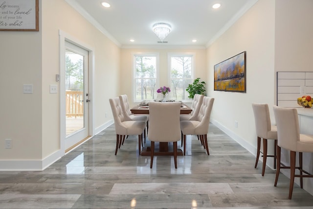 dining space with baseboards, crown molding, and recessed lighting