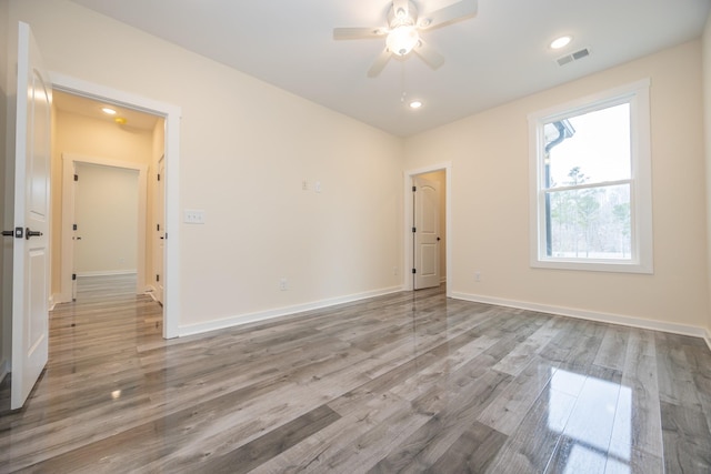 spare room featuring recessed lighting, wood finished floors, a ceiling fan, visible vents, and baseboards