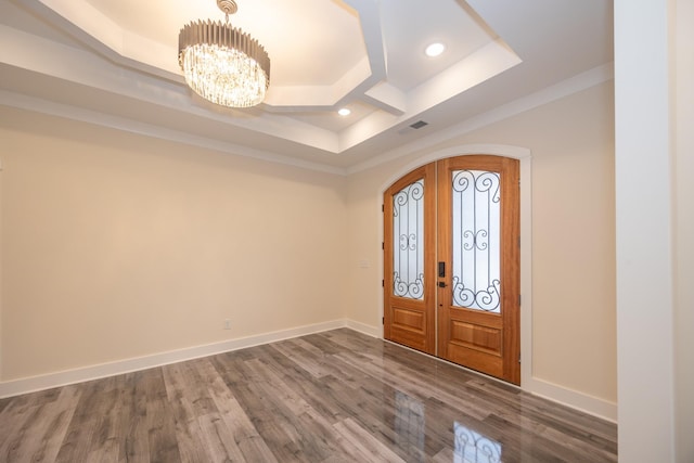 foyer entrance with baseboards, visible vents, arched walkways, wood finished floors, and a notable chandelier