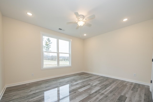 empty room featuring baseboards, wood finished floors, and recessed lighting