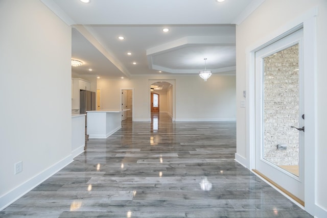 unfurnished living room featuring arched walkways, wood finished floors, baseboards, and recessed lighting