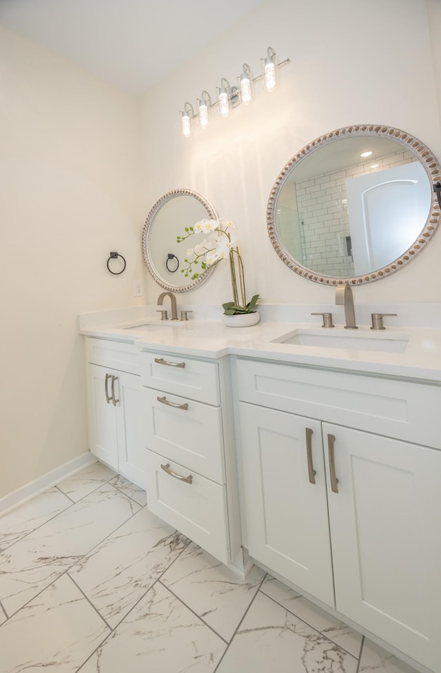 full bathroom with double vanity, marble finish floor, and a sink