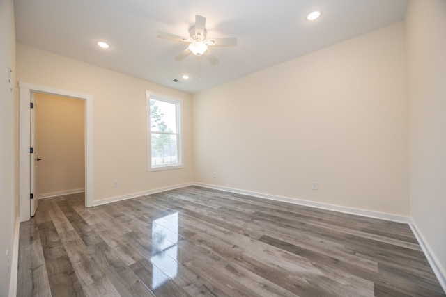 empty room featuring ceiling fan, baseboards, dark wood-type flooring, and recessed lighting