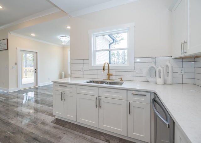 kitchen featuring crown molding, a healthy amount of sunlight, white cabinets, a sink, and dishwasher