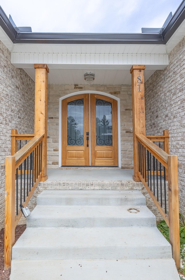 doorway to property with stone siding and french doors