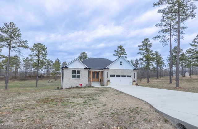 single story home with driveway, brick siding, an attached garage, and a front yard