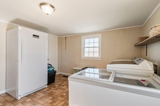 laundry room with crown molding, laundry area, brick floor, and independent washer and dryer