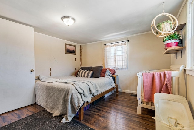 bedroom featuring baseboards, dark wood-style flooring, and crown molding