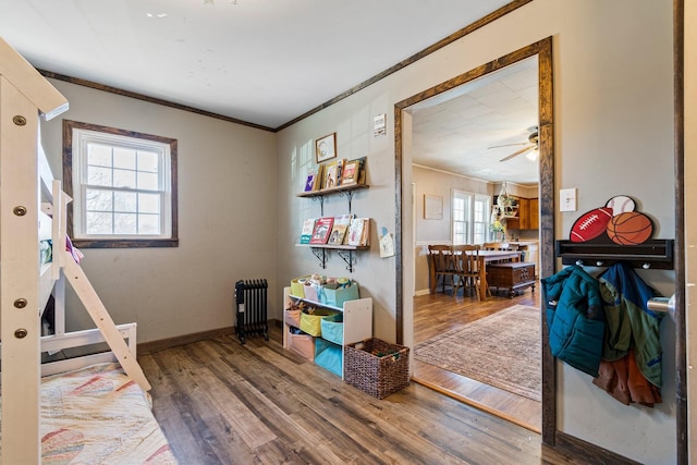 interior space with crown molding, baseboards, and wood finished floors