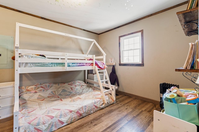 bedroom featuring baseboards, electric panel, ornamental molding, and wood finished floors