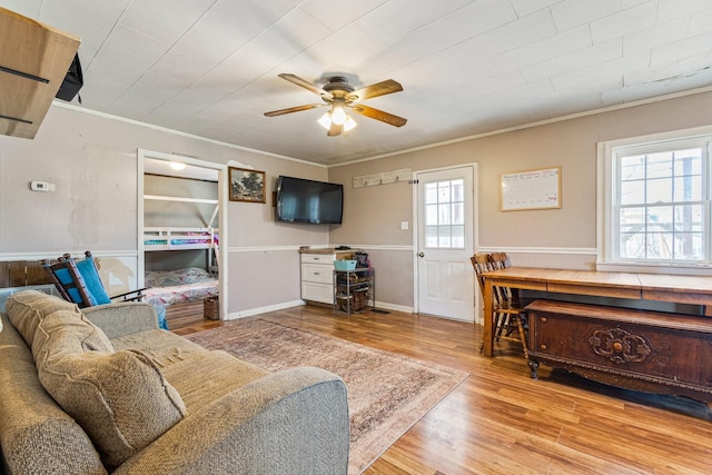 living area featuring ornamental molding, ceiling fan, and wood finished floors