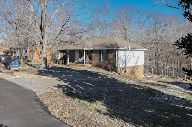 view of front of home featuring brick siding and a porch