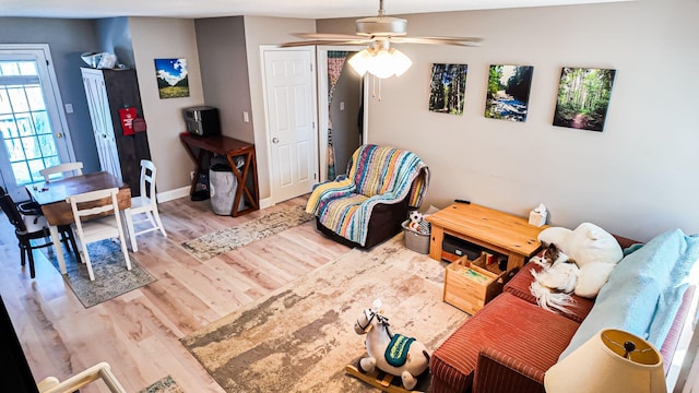 living area with light wood-type flooring and baseboards