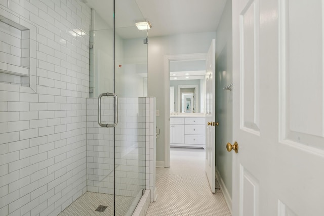 bathroom with baseboards, a shower stall, vanity, and tile patterned floors