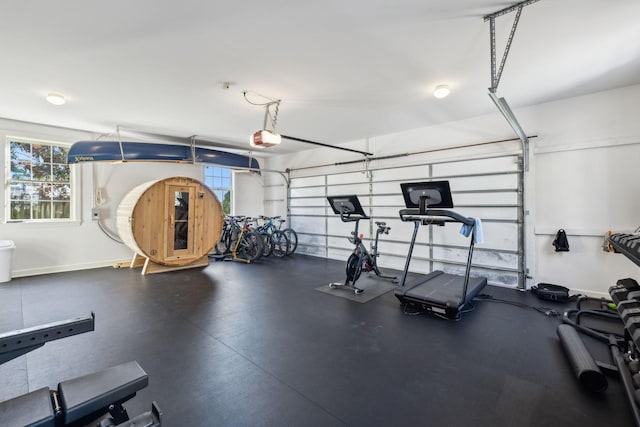 workout area featuring a garage, plenty of natural light, and baseboards