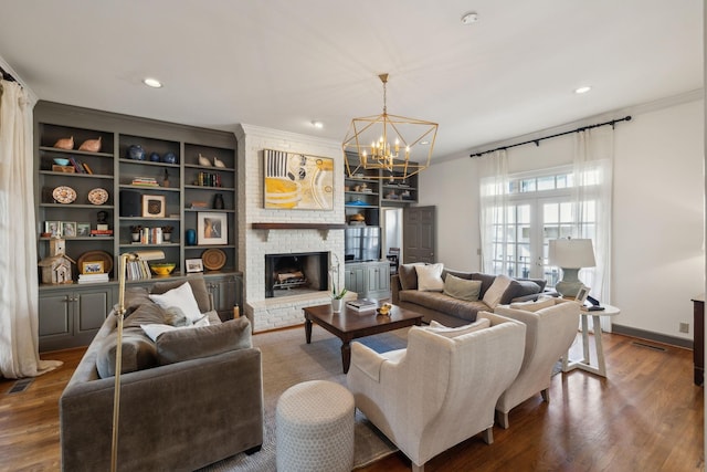 living room with recessed lighting, built in features, ornamental molding, a brick fireplace, and dark wood-style floors