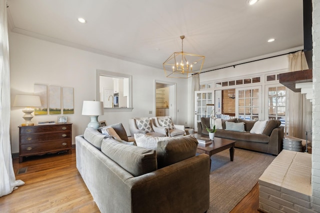 living area with light wood-style floors, recessed lighting, crown molding, and an inviting chandelier