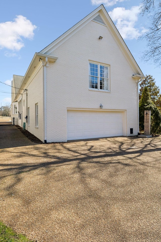 view of side of home with a garage and brick siding