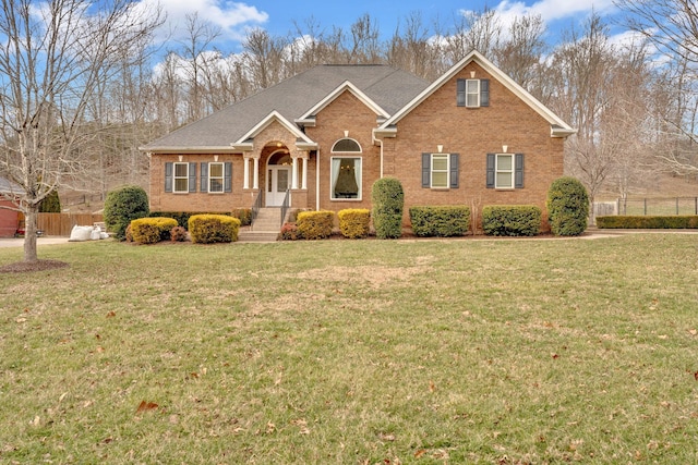 view of front of property featuring brick siding, a front lawn, and fence