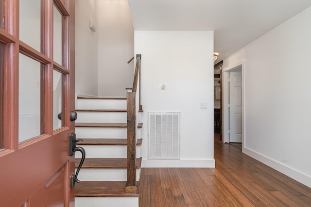 stairway with baseboards, visible vents, and wood finished floors