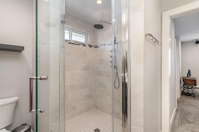 bathroom featuring a shower stall and toilet