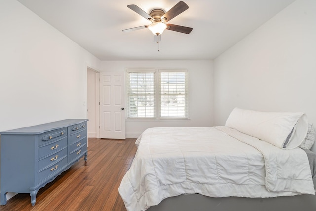 bedroom with dark wood-style floors, a ceiling fan, and baseboards