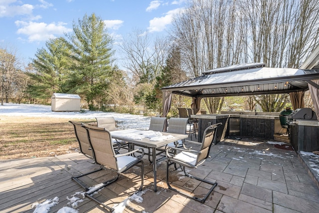 view of patio with a gazebo, a storage shed, outdoor dining space, a deck, and an outdoor structure