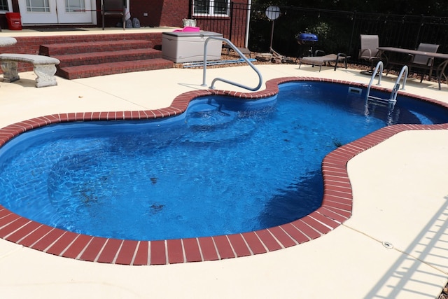 view of pool with french doors, a patio area, fence, and a fenced in pool