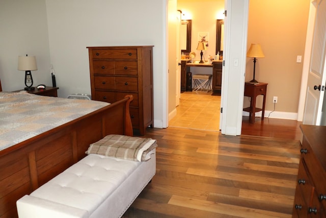 bedroom with baseboards and wood finished floors