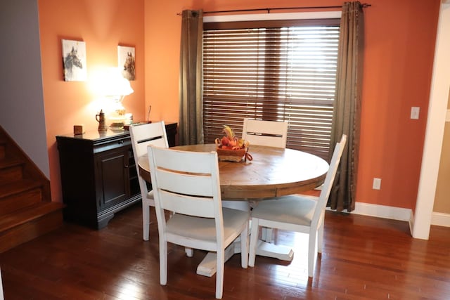 dining room with dark wood-type flooring, stairway, and baseboards