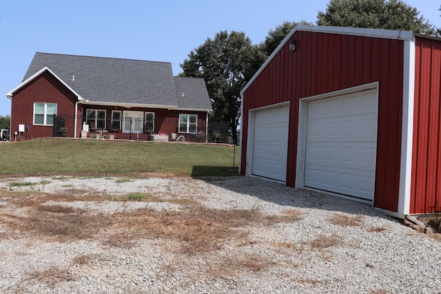 view of front facade featuring a porch, a front yard, a detached garage, and an outdoor structure