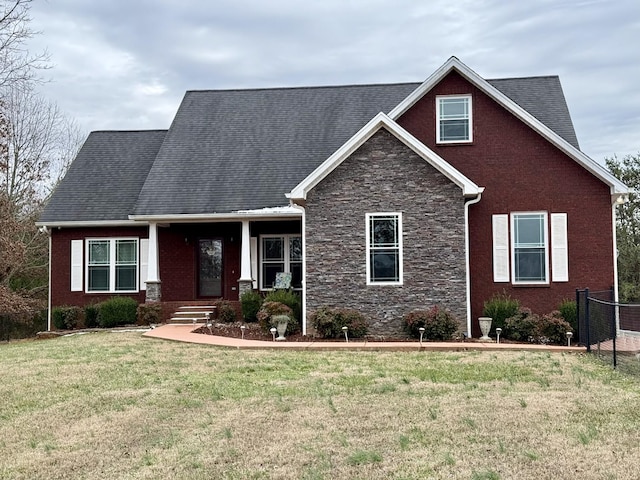 craftsman-style house featuring stone siding, a porch, and a front yard