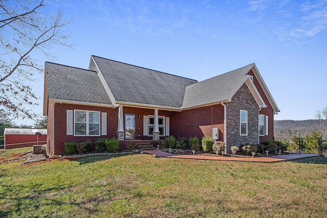 craftsman-style house with brick siding, a front yard, fence, and a shingled roof