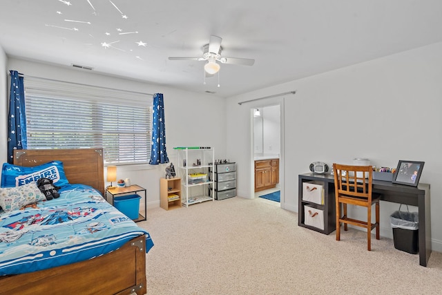 bedroom featuring light colored carpet, visible vents, ceiling fan, ensuite bath, and baseboards