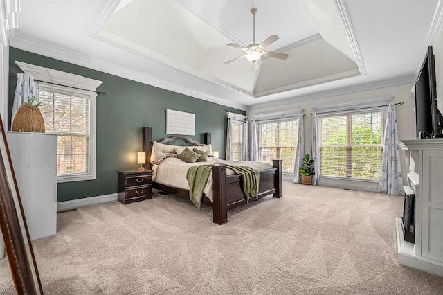 bedroom featuring light carpet, a raised ceiling, and crown molding