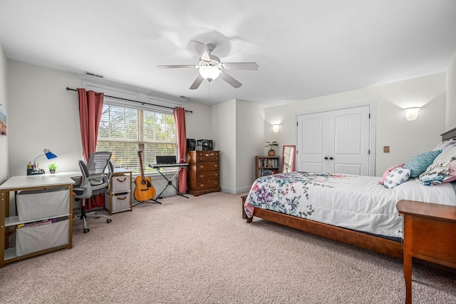 carpeted bedroom with a closet, visible vents, and a ceiling fan