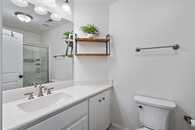 full bath featuring a shower with shower door, toilet, visible vents, vanity, and baseboards