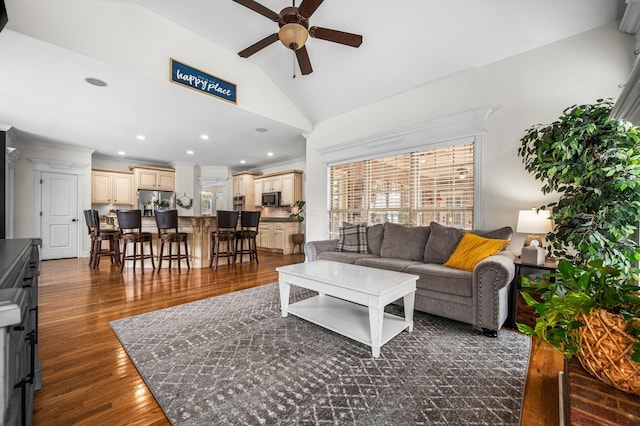 living area featuring a ceiling fan, dark wood-style flooring, vaulted ceiling, crown molding, and recessed lighting