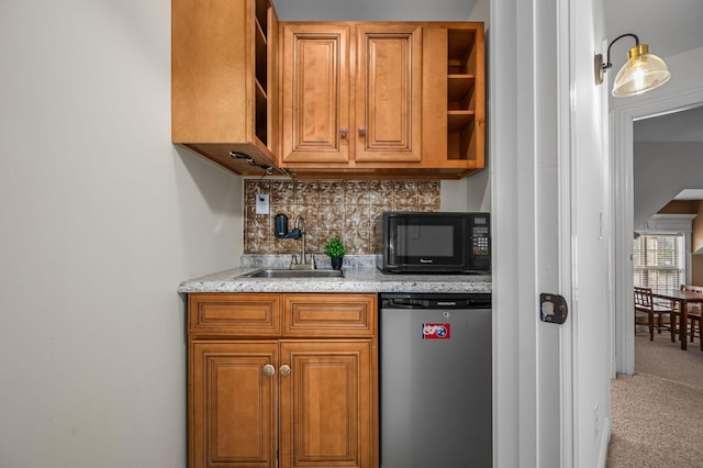 kitchen with black microwave, a sink, stainless steel refrigerator, brown cabinets, and open shelves