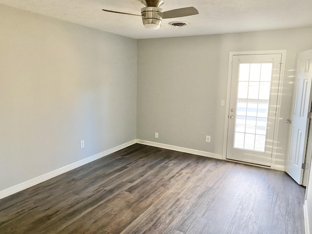 empty room with baseboards, dark wood-style flooring, a ceiling fan, and a healthy amount of sunlight